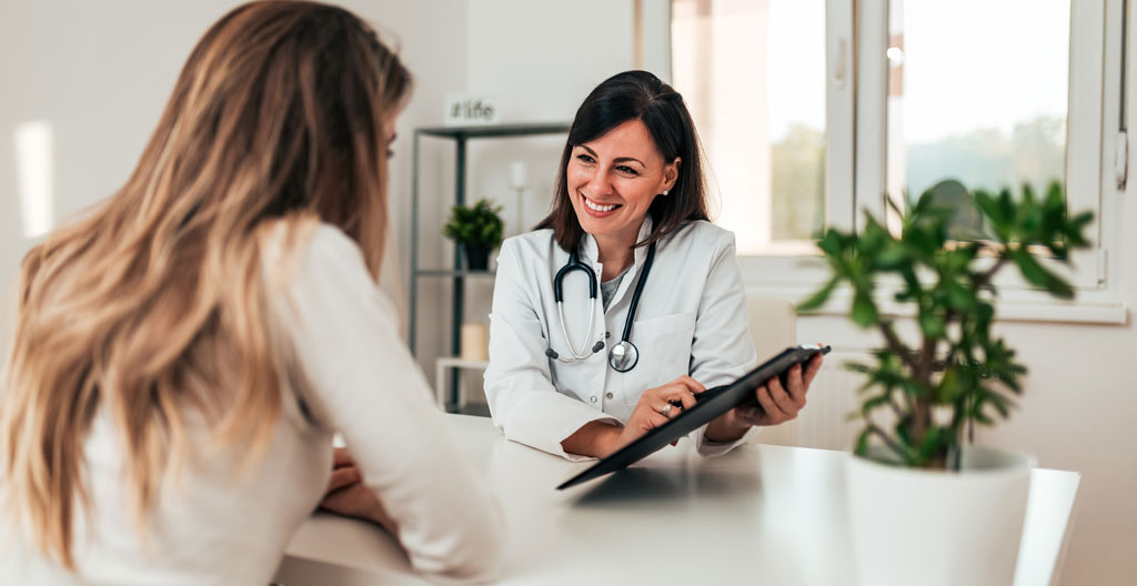 Patiente de dos consultant un document médical avec un professionnel de santé dans un cabinet lumineux moderne
